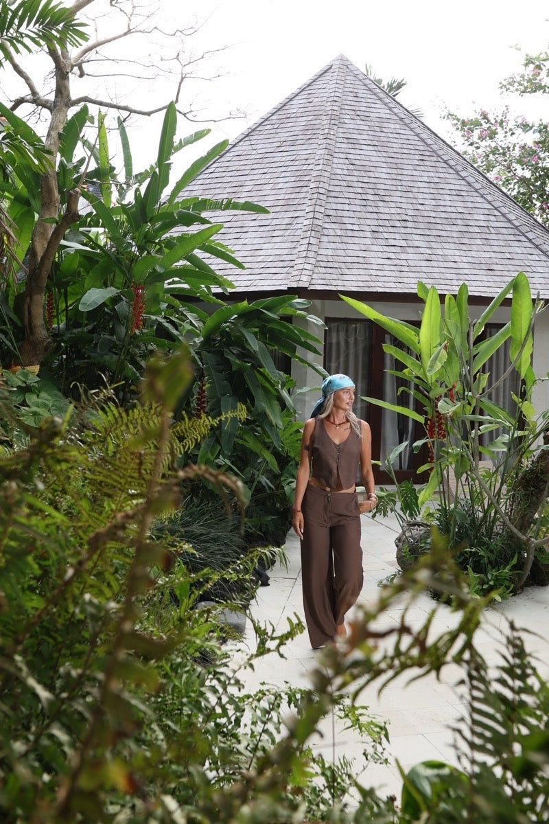 woman wearing MOSS The Label Sol pants and sunset vest in brown in a bali villa